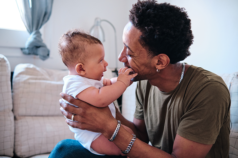 smiling father holding his cute infant son