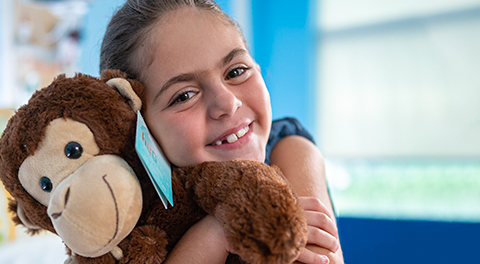 Nikki, hugging a stuffed animal