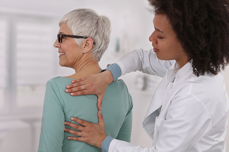 Doctor relieving pressure from patient back.