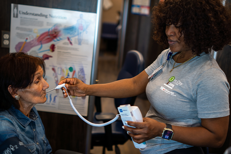 Marie Guilloux taking temperature of attendee at OCAT Hollywood