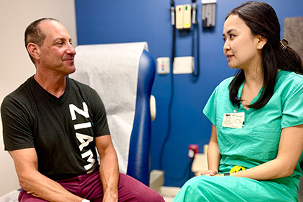 Scott talking to Dr. Christine Feng in an exam room during a check-up visit.